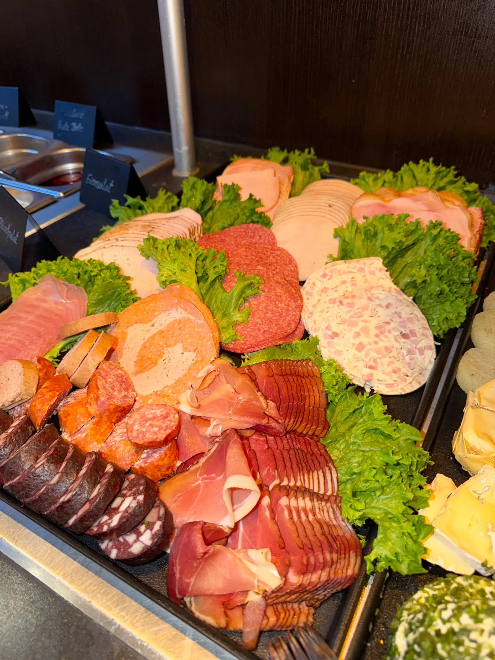 Reichhaltige Buffetplatte mit Schinken, Salami, Bratenaufschnitt und frischem Blattsalat