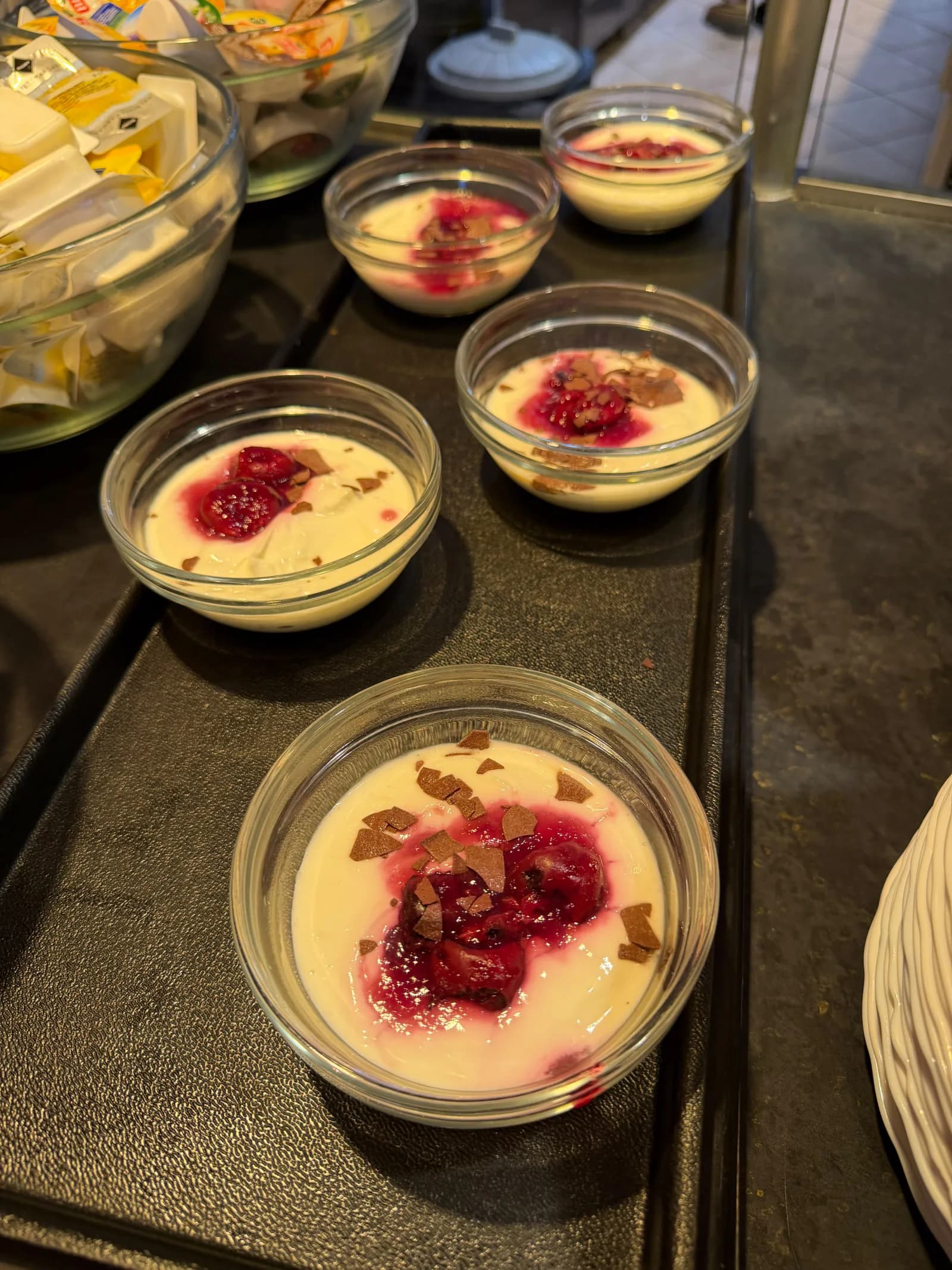 Kleine Dessertgläser mit Creme, roter Fruchtsoße und Schokoladenstückchen