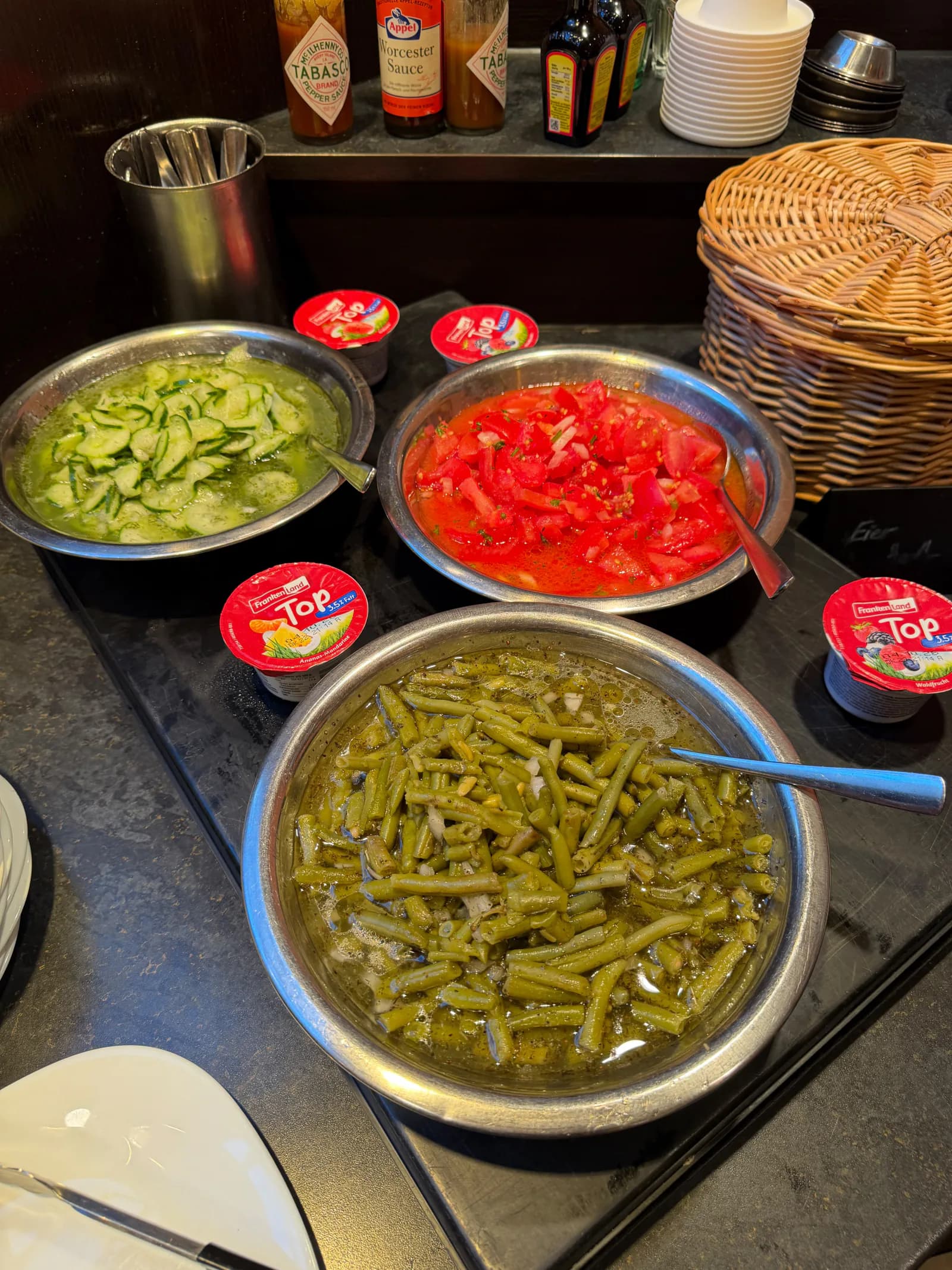 Frische Gurken-, Tomaten- und Bohnensalate mit Portionsjoghurt am Buffet