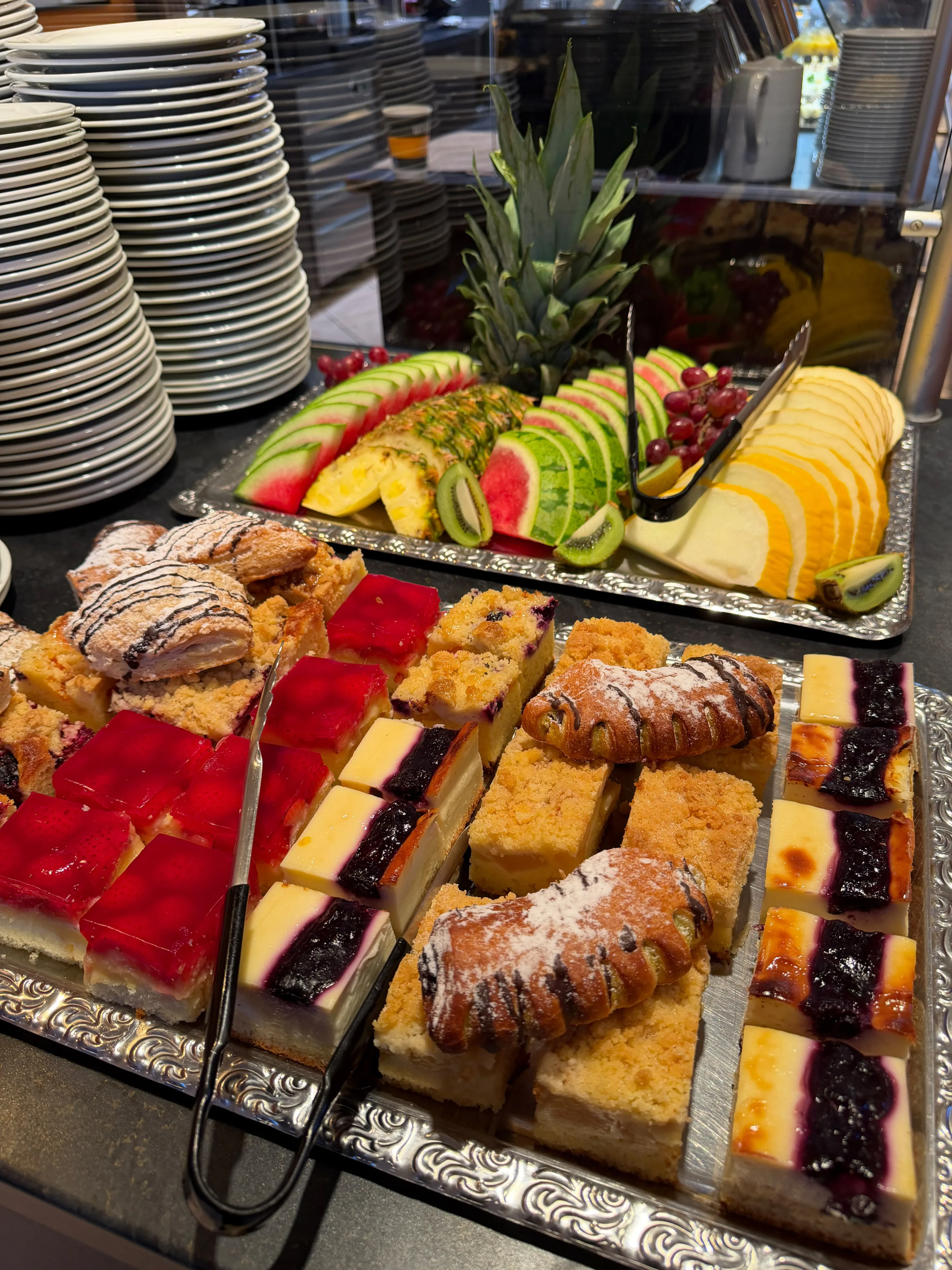 Frühstücksbuffet mit frischem Obst, verschiedenen Kuchenstücken und Gebäck