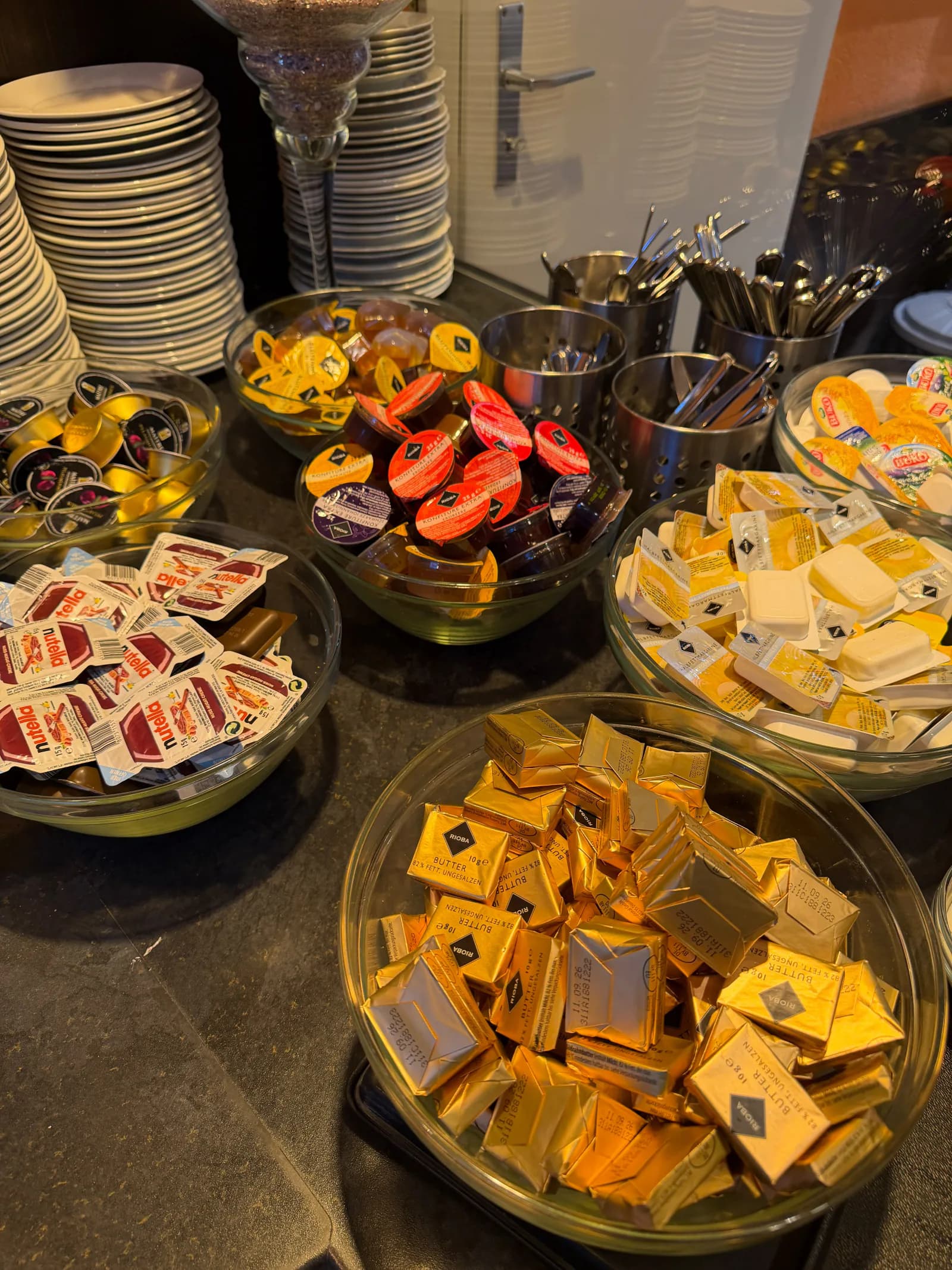 Auswahl an Butter, Konfitüre, Honig, Nuss-Nougat-Creme und weiteren Portionsaufstrichen