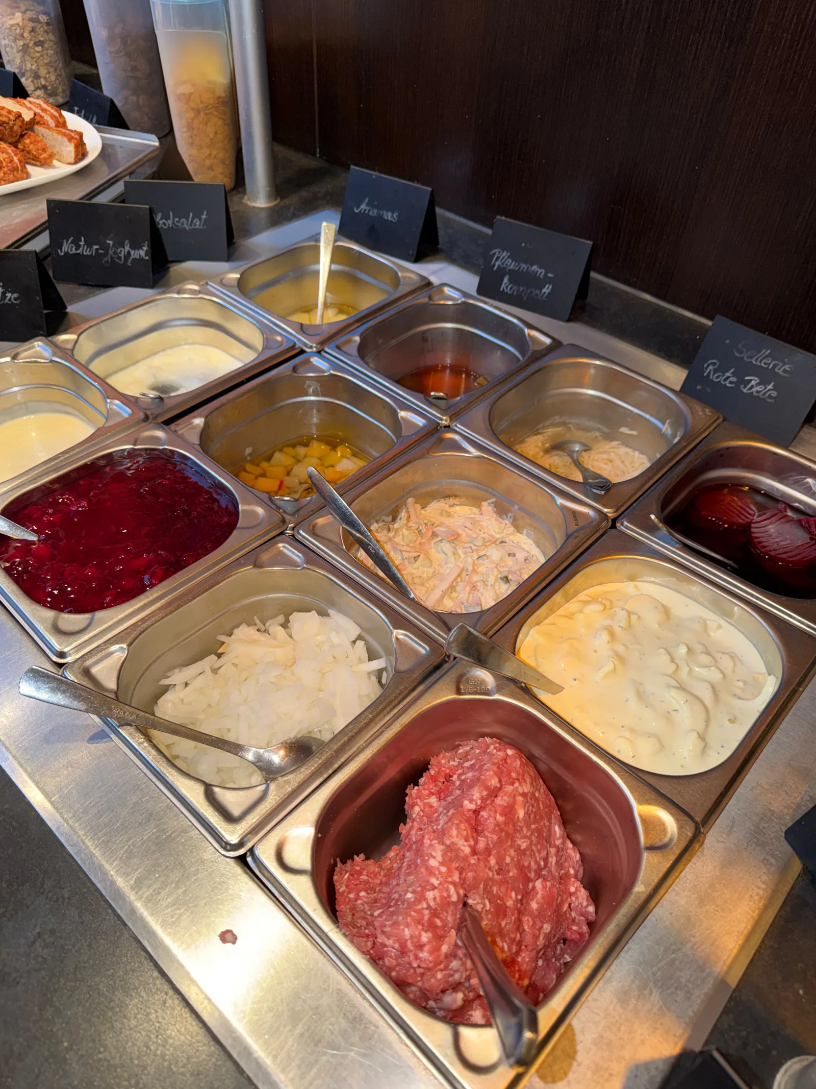 Buffetauswahl mit verschiedenen Salaten, Joghurt, Kompott und herzhaften Beilagen