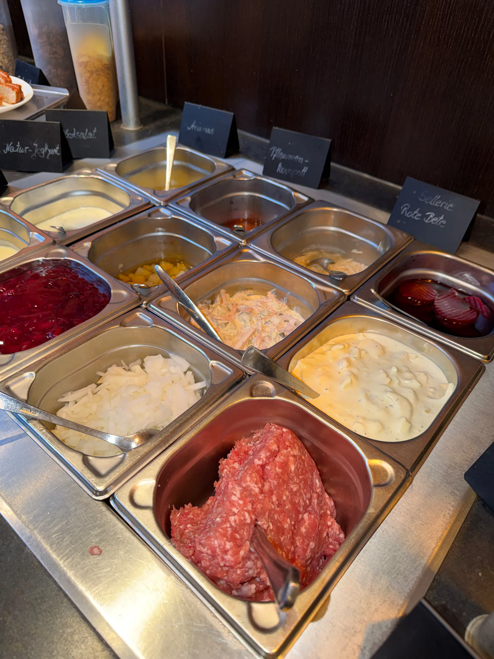 Verschiedene Salate, Joghurt, Kompott und herzhafte Beilagen am Buffet