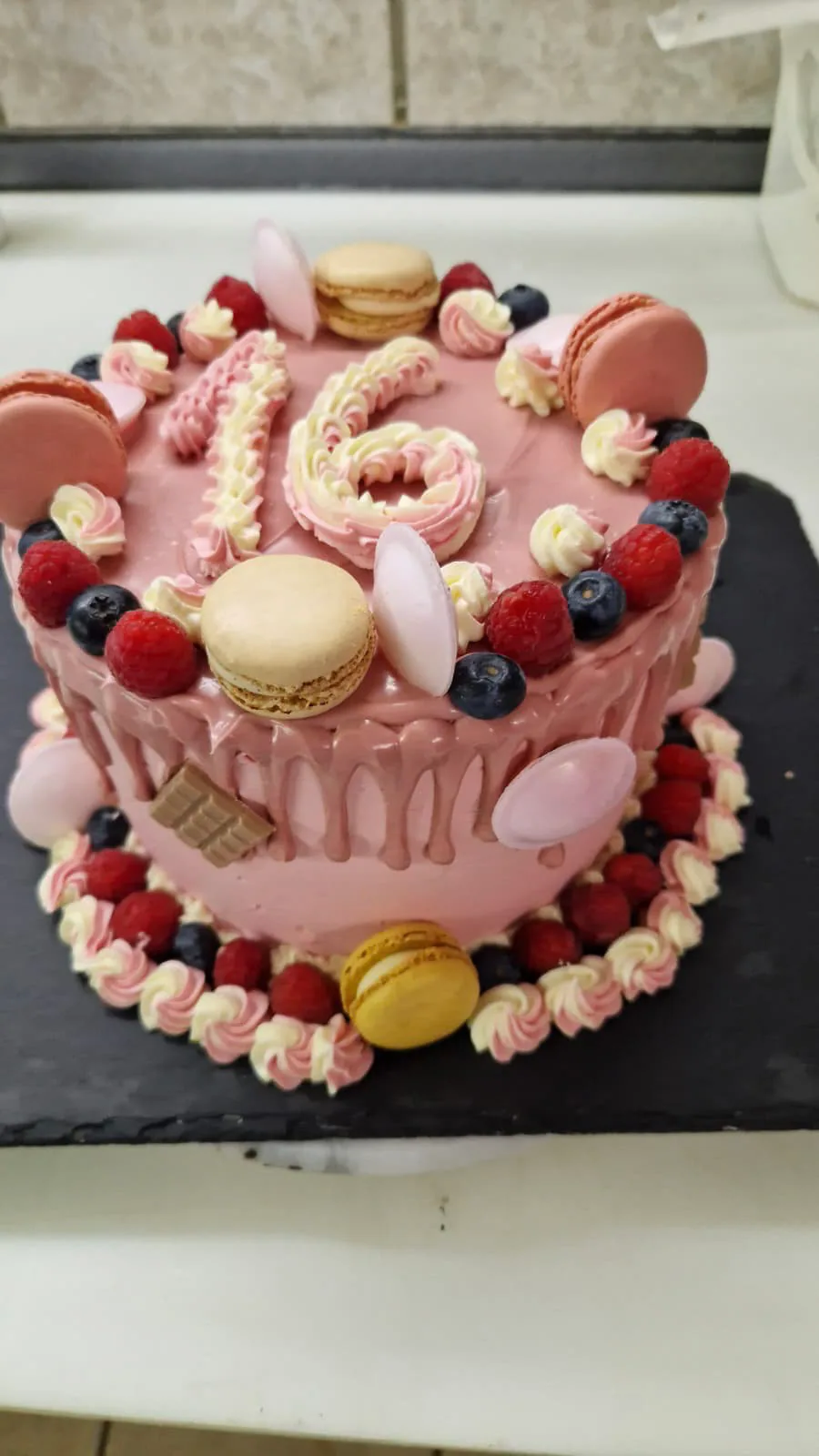 Rosa Geburtstagstorte mit Macarons, Himbeeren und Heidelbeeren